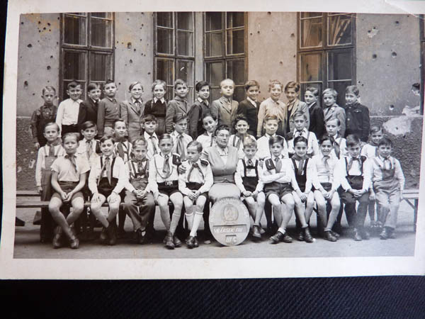 TK: Class photo. The walls still bear the bulletholes from the siege of Budapest December 1944 - January 1945. Budapest, 1954