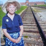 HN: In Auschwitz, 2010. "Six years ago, when I was eighty, I went to Auschwitz. And I knew my father by then had died there. And I wanted to have a photograph taken of me standing on the railway line, where my... railway carriage would, would, would stop. And then I also wanted to go to the selection gate. Cause I knew one way used to live and one way to die. I found out that my father lived... for three months. It was quite an experience to go to Auschwitz. One I wouldn’t like to do again."