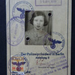 AK: Travel document, 1938. "Well this is my exit card from Germany, as well as my entry card to England, Southampton. At the top, you'll notice the stamp. Hamburg, from where I left Germany on a boat- on a boat called The Manhattan. And it's dated 19th of April 1939 with the German Eagle stamp and then below that there is the English stamp, “landed at Southampton” with my photograph. And then at the bottom there’s a rather interesting little comment, it says, “Leave to land at Southampton granted to the holder, provided the holder does not enter any employment while in the UK, either paid or unpaid.” Well, it is a bit of a joke because I was then ten years old, so it was I likely to take any employment, paid or unpaid?"