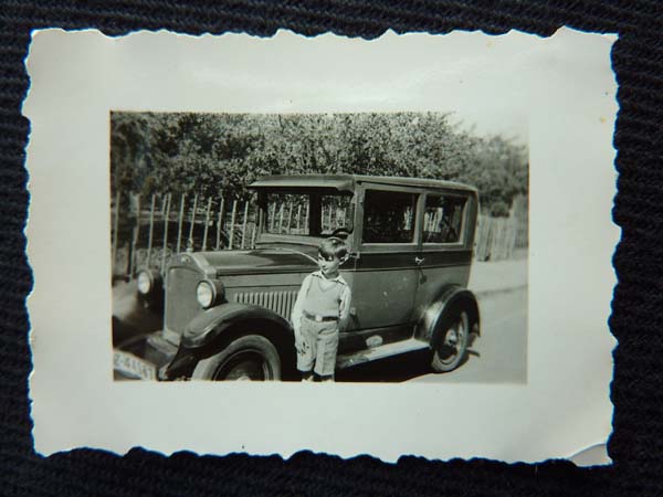 KM: With the family's first car, a small Opel, ca1931. "I put it into gear. And I used the starter. You see you- you didn't need an ignition key to work the starter; it had a button on the floor of the car. I put it in gear and each time the battery turned over the engine - car moved. So, I must have driven- gone about 100 yards with it. So, it was well down the street. [laughs] I had driven it. My father was not pleased. I seem to remember that."