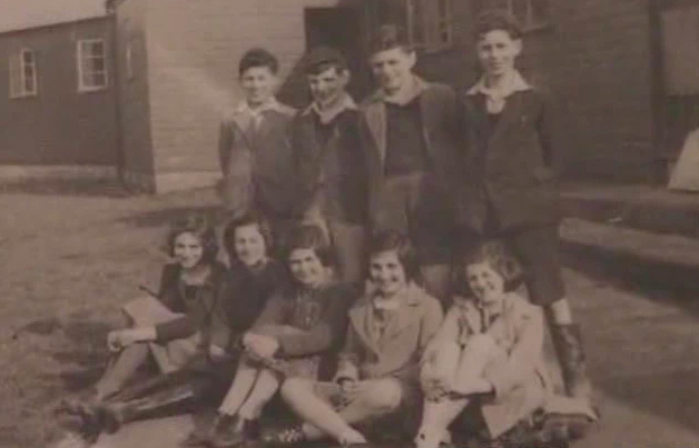 GJ: With other refugee children, Millisle Refugee Settlement Farm, County Down, Northern Ireland, 1943. "I am this person here, this lovely young boy, and they are the children together, we are being taken in front of the huts"