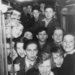 LB: Leslie on Kindertransport train, top centre, 1938. "here we have a group of children in the compartment of a German train, immediately after leaving Germany and crossing into Holland. This was posed for a Dutch photographer, who wanted to take this picture. And, apart from myself, there are at least two other boys who came from the Jewish orphanage. I am at the top centre of this picture, looking rather anxious, I must say. Despite the fact that we just crossed into safety, the German-Dutch border, I must say that I do look rather anxious and like a boy who doesn’t quite know what the future holds, which indeed I didn’t. "
