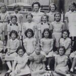 LL: South Hampstead High School, LL in the first row, second child in from the left, holding a gift from Lola: a pair of silver Dutch clogs keyring