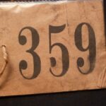 OH: Number tag issued to OH on registration for Kindertransport. 4th December 1938. 360 children were registered that day. "I keep it in the Shemot. The- in my- I’ll show you, in my book - Exodus. Right? Shemot. I keep it inside there."