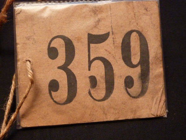 OH: Number tag issued to OH on registration for Kindertransport. 4th December 1938. 360 children were registered that day. "I keep it in the Shemot. The- in my- I’ll show you, in my book - Exodus. Right? Shemot. I keep it inside there."