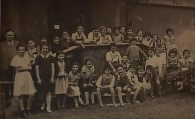 BG: Jewish school, Munich, 1936, BG resting her hands on her knees and bending forwards. "I am with all the rest of the class, most of whom, of course did not survive; I think out of the whole class only four of us survived."